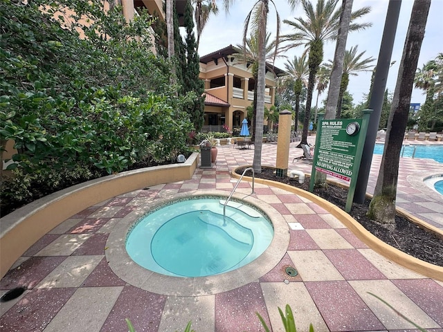 view of swimming pool featuring a hot tub