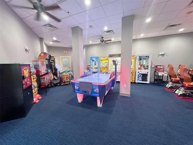 playroom with a paneled ceiling and dark carpet