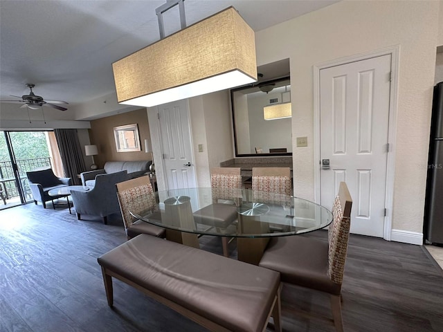 dining space featuring ceiling fan and dark wood-type flooring