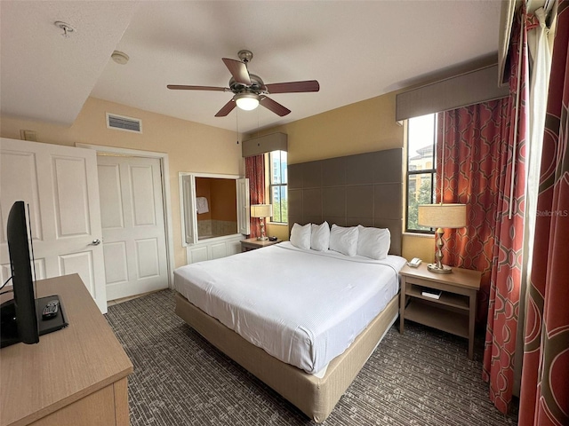 bedroom featuring dark colored carpet and ceiling fan