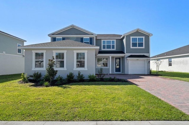 view of front of property with a garage, a front lawn, and decorative driveway