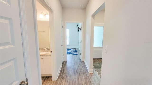 hallway featuring sink and light wood-type flooring