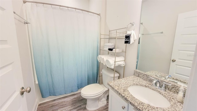 bathroom with hardwood / wood-style floors, toilet, and large vanity