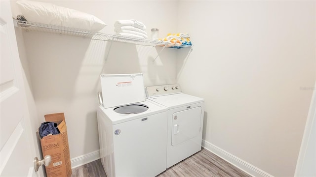 laundry area featuring hardwood / wood-style floors and washing machine and dryer