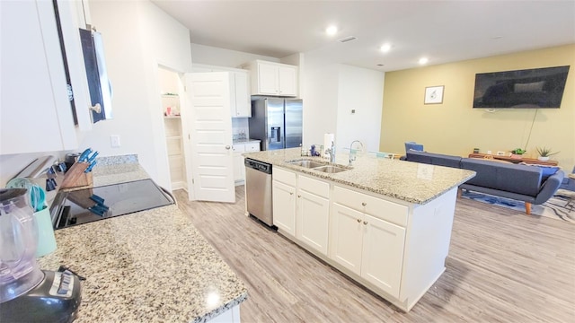 kitchen featuring a center island with sink, light wood-type flooring, sink, and appliances with stainless steel finishes