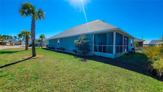 view of side of home featuring a yard and a sunroom