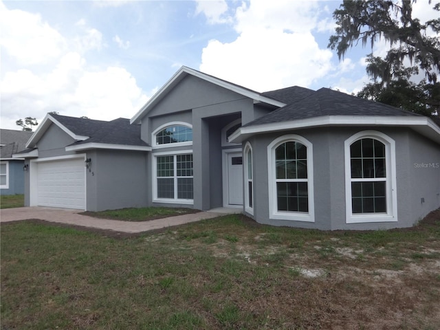 single story home featuring a garage and a front yard