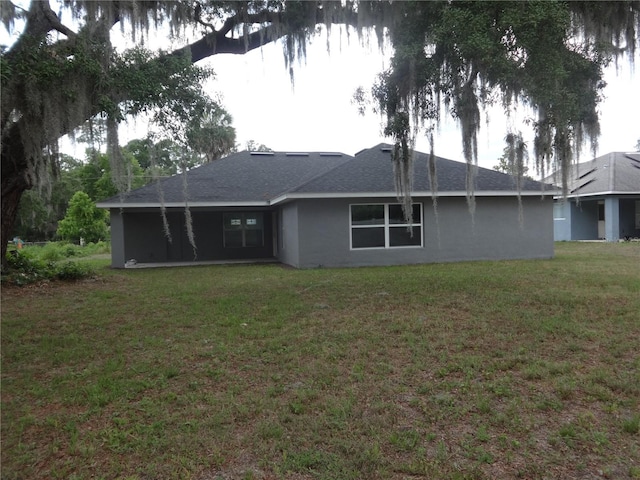 rear view of house featuring a lawn