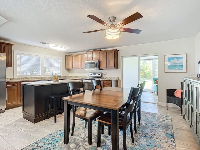 dining room with ceiling fan and a textured ceiling