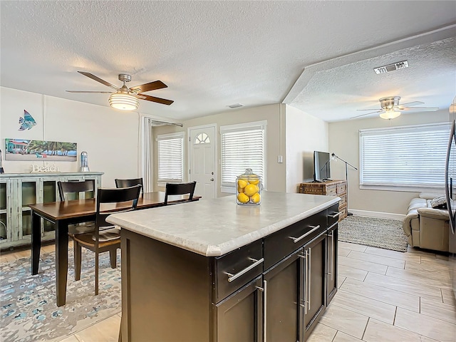 kitchen featuring a wealth of natural light, a textured ceiling, and a kitchen island