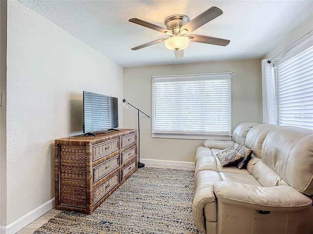 sitting room with a textured ceiling, a healthy amount of sunlight, and ceiling fan