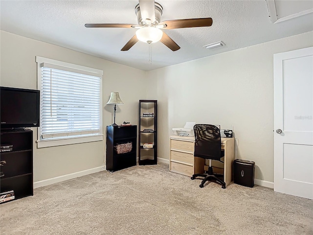 carpeted home office with ceiling fan and a textured ceiling