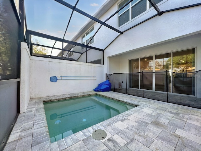 view of pool with a patio area, glass enclosure, and an in ground hot tub