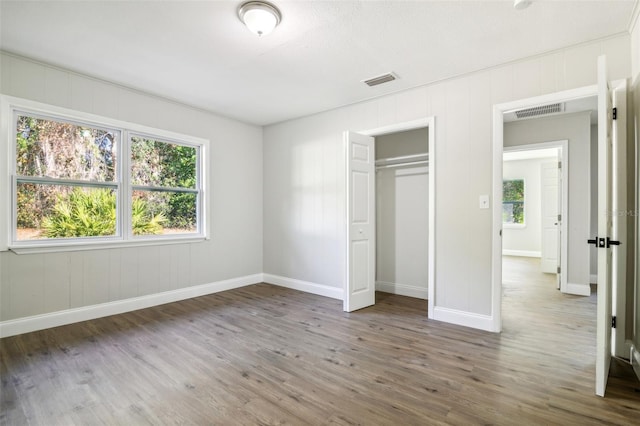 unfurnished bedroom featuring dark hardwood / wood-style flooring and a closet