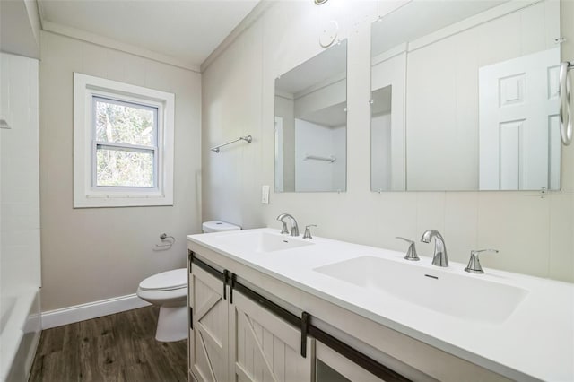 bathroom with wood-type flooring, vanity, toilet, and ornamental molding