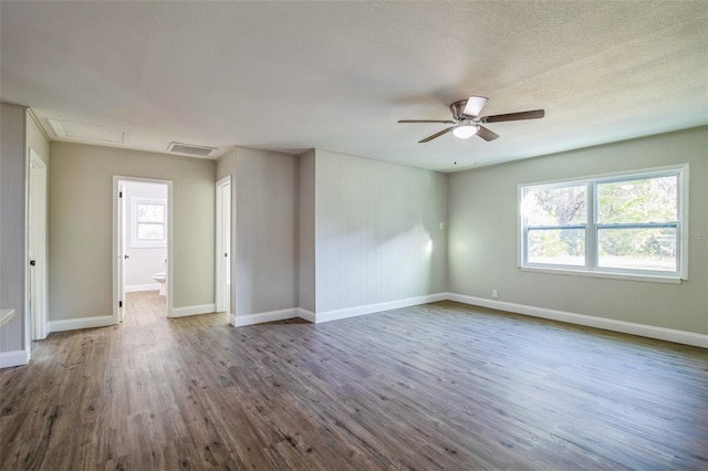 unfurnished room featuring ceiling fan, a healthy amount of sunlight, wood-type flooring, and a textured ceiling