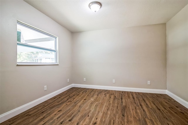 unfurnished room with dark hardwood / wood-style flooring