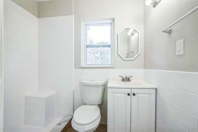 bathroom with vanity, tile walls, and toilet