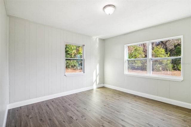 spare room with hardwood / wood-style floors and wooden walls