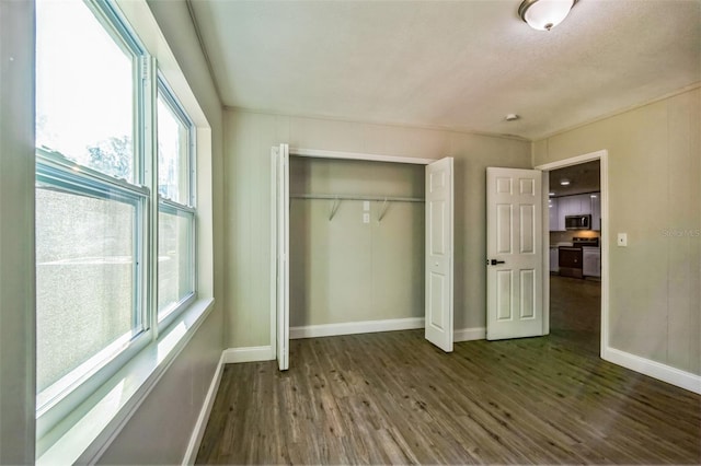 unfurnished bedroom featuring dark hardwood / wood-style flooring, a textured ceiling, and a closet