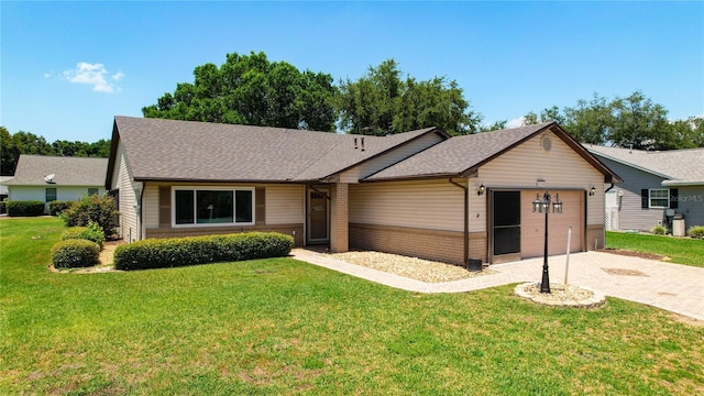 ranch-style house with a garage, a front yard, and decorative driveway