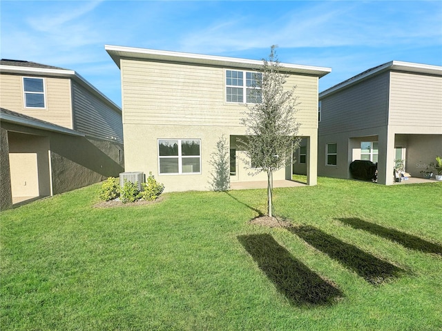 back of house with central AC, a patio area, and a lawn