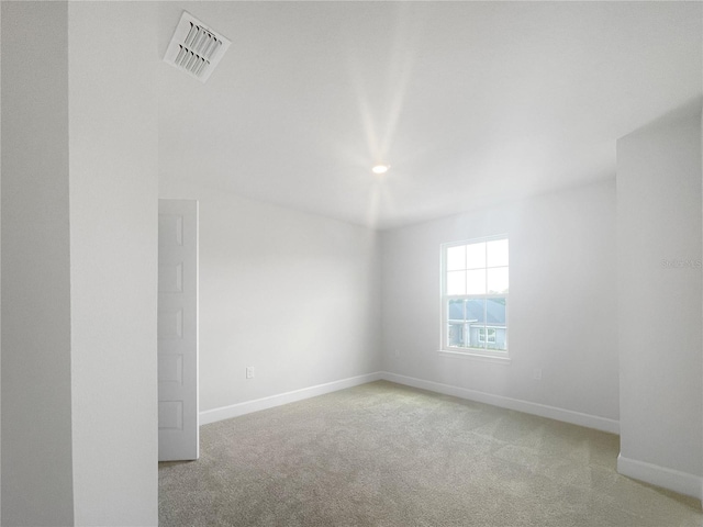 spare room featuring light carpet