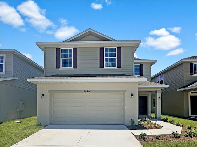 view of property featuring a front lawn and a garage