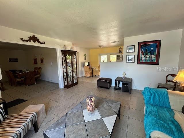 7313 Cabor Ct, Orlando, FL 32818 - tiled living area with a textured ceiling