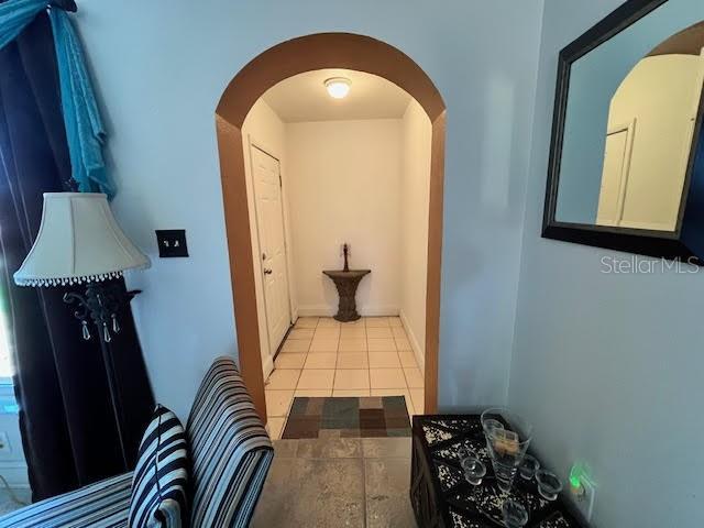 7313 Cabor Ct, Orlando, FL 32818 - hallway with arched walkways and tile patterned floors