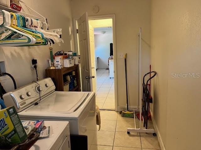 washroom with washing machine and clothes dryer and light tile patterned floors