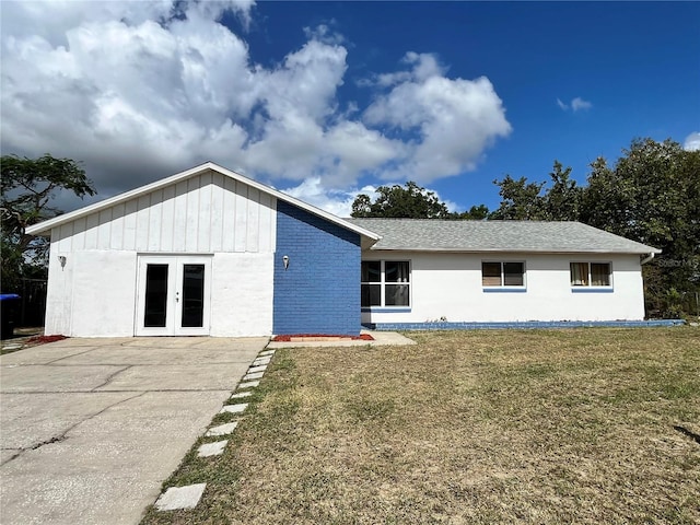 back of house with french doors and a yard