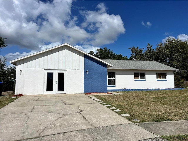 7313 Cabor Ct, Orlando, FL 32818 - view of front facade featuring roof with shingles, a front yard, and french doors