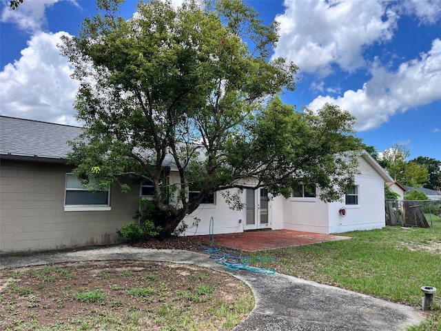 7313 Cabor Ct, Orlando, FL 32818 - exterior space featuring concrete block siding, french doors, fence, a shingled roof, and a front yard