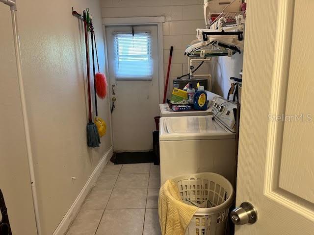 clothes washing area featuring light tile patterned flooring and separate washer and dryer