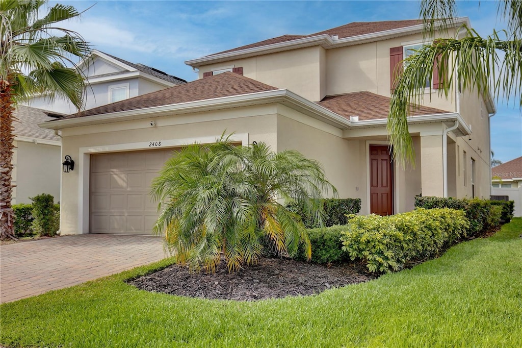 view of front of property featuring a garage and a front lawn