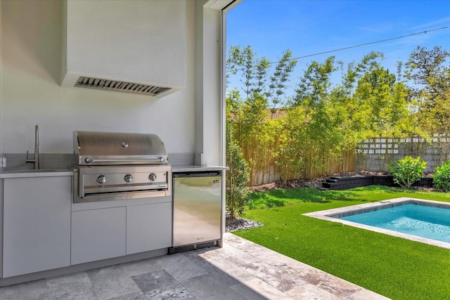 view of patio / terrace with a fenced in pool, sink, exterior kitchen, and grilling area