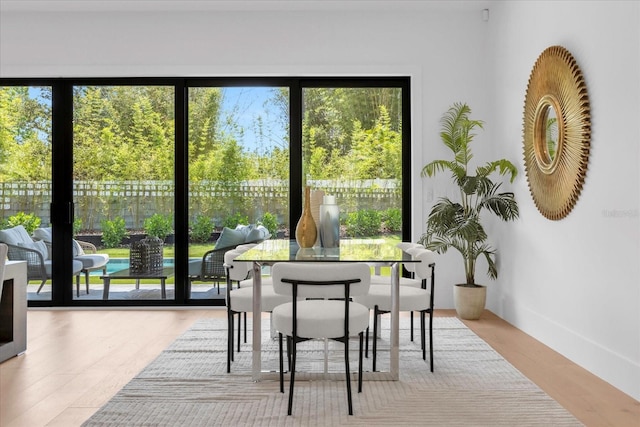 dining area with a wealth of natural light and hardwood / wood-style flooring