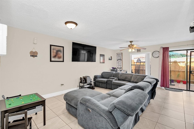 living room with ceiling fan, a textured ceiling, and light tile floors