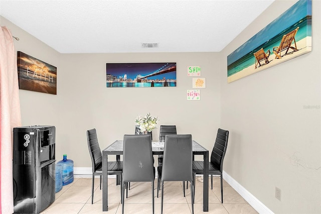 tiled dining space featuring a textured ceiling