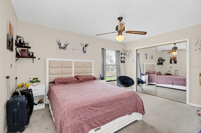 carpeted bedroom featuring a closet, ceiling fan, and a textured ceiling