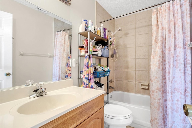 full bathroom featuring shower / bath combination with curtain, a textured ceiling, toilet, and vanity