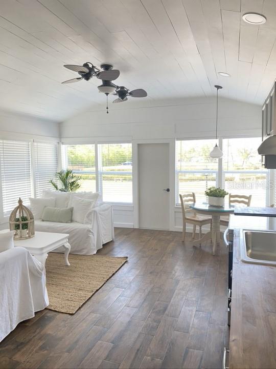 interior space with dark wood-type flooring, sink, ceiling fan, and vaulted ceiling