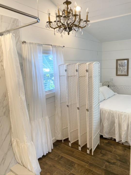 bedroom with a chandelier, dark hardwood / wood-style floors, and vaulted ceiling