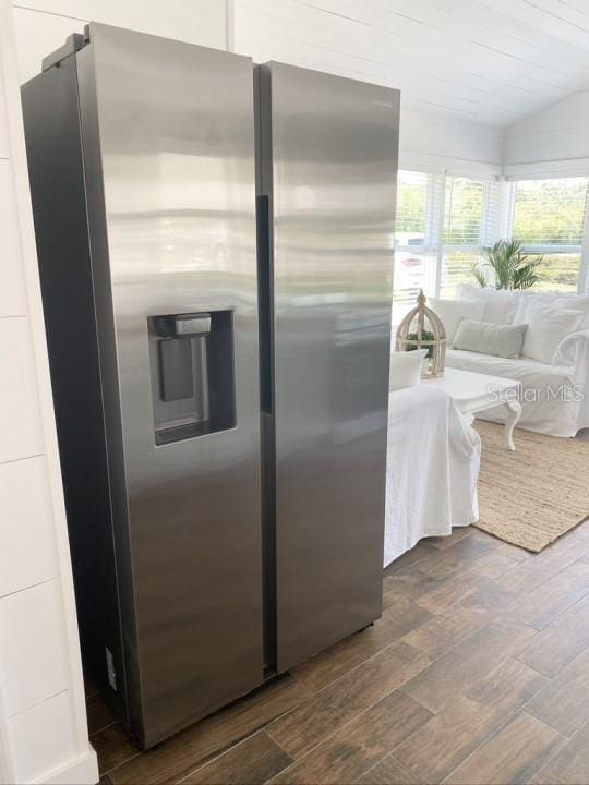 kitchen with stainless steel fridge with ice dispenser, dark hardwood / wood-style floors, and lofted ceiling