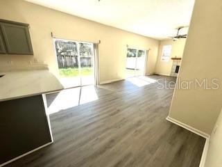 unfurnished living room with a healthy amount of sunlight and dark wood-type flooring