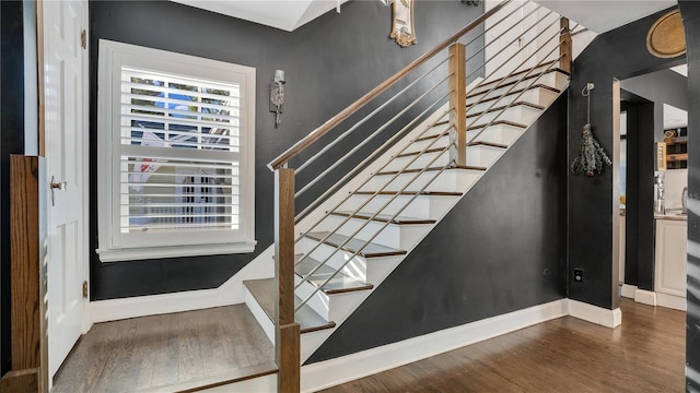 stairway featuring baseboards and wood finished floors