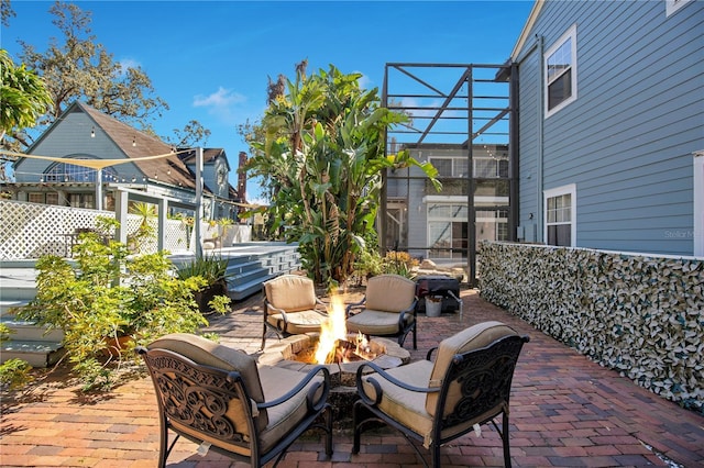 view of patio with a lanai and a fire pit