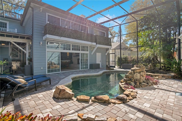 pool with glass enclosure and a patio area