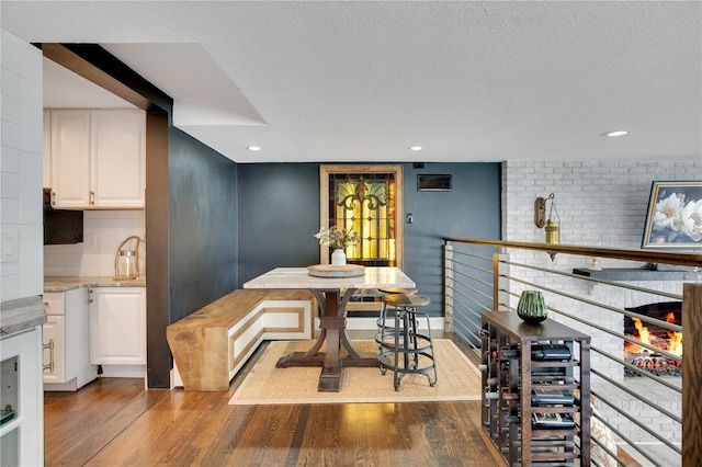 dining area with recessed lighting, a textured ceiling, and dark wood-style floors